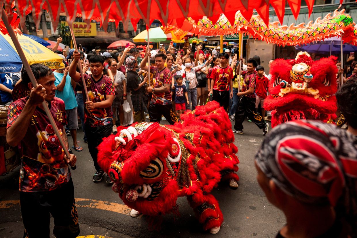 Dragon and Lion dancers perform during Lunar New Year celebrations at Chinatown in Binondo, Manila, Philippines, on Tuesday, February 17, 2026. -- Photo: REUTERS/Lisa Marie David