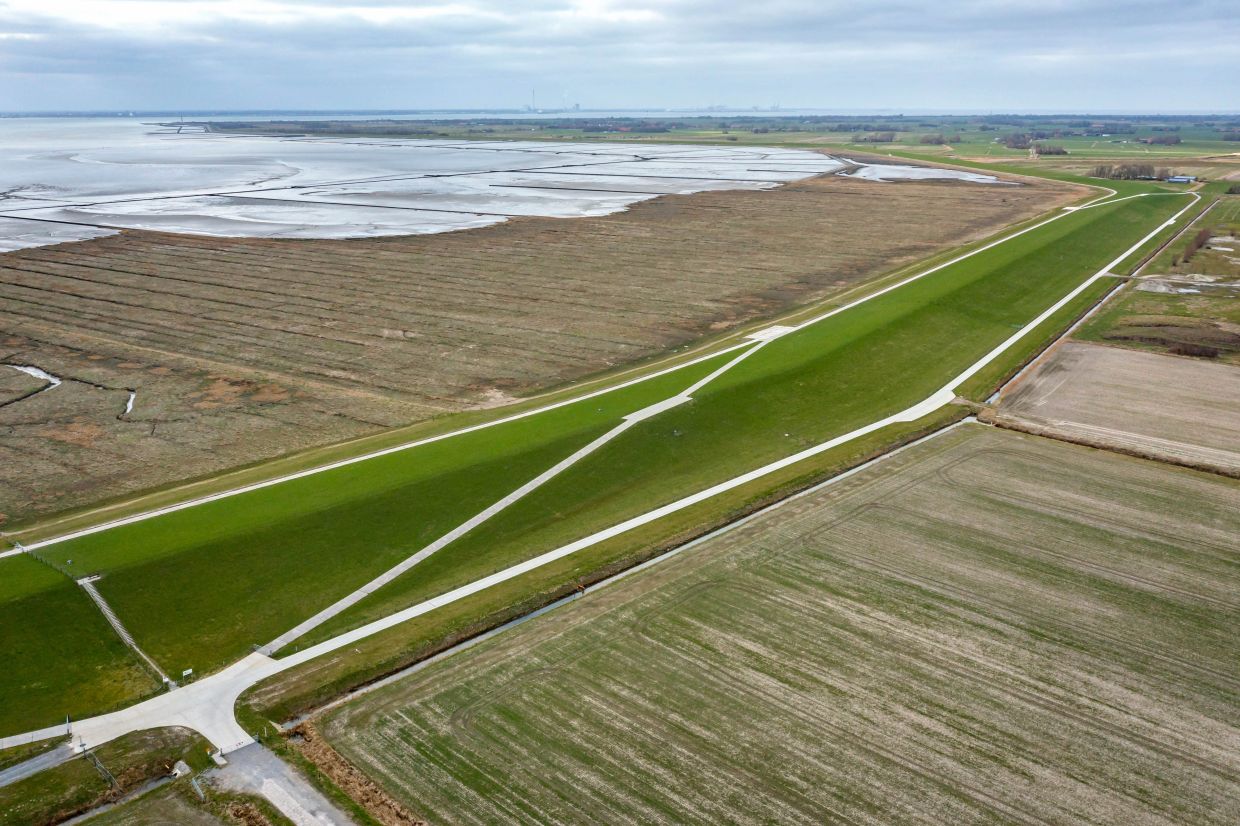 A dyke in the Wesermarsch in Lower Saxony. Dykes are supposed to protect residents from rising sea levels. — Photo: Sina Schuldt/dpa
