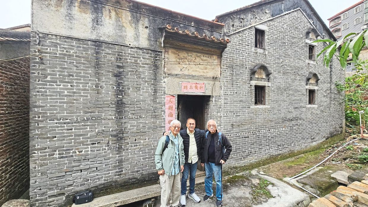 The writer (centre) with his two cousins, Tony and Patrick from Hong Kong, in front of their grandfather's house.