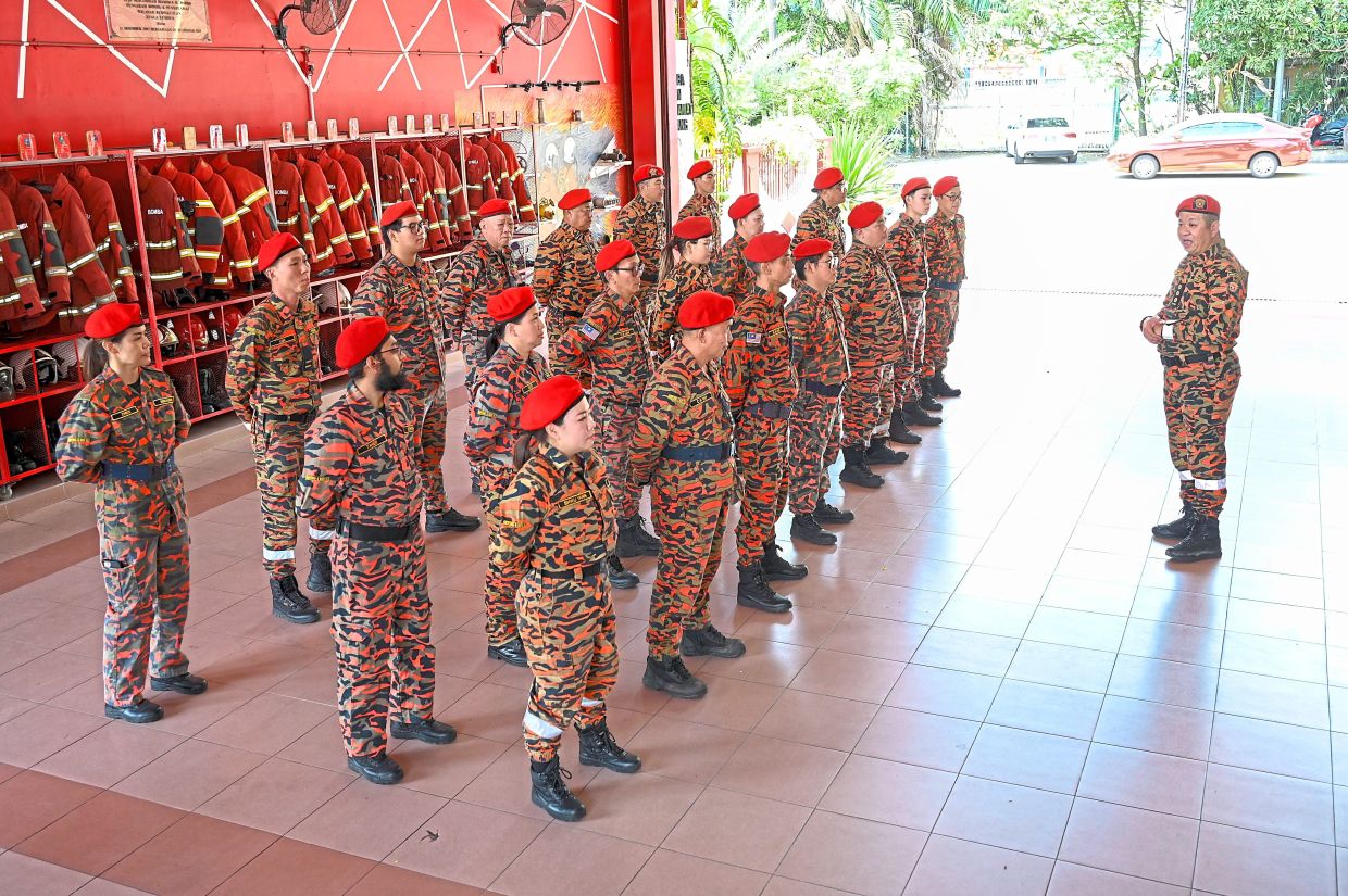 Kepong and Batu Volunteer Fire Department team members (from left) Lum Wai Kit, Ng Kok Hung, Chua Shwu Yann, Soong Mei Ling and Chiam Da Wei putting on their fire-resistant gear during a training session. — Photos: IZZRAFIQ ALIAS/The Star Loke (right) speaking to his team during a training session at Jinjang Fire and Rescue Station in Kuala Lumpur.