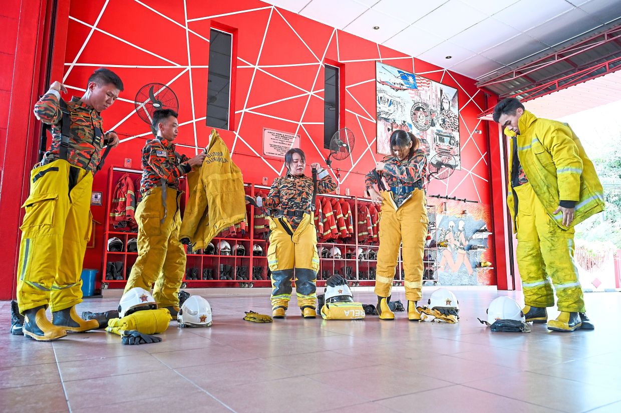 (From left) Lum Wai Kit, Ng Kok Hung, Chua Shwu Yann, Soong Mei Ling and Chiam Da Wei putting on their fire-resistant gear during a training session. — IZZRAFIQ ALIAS/The Star