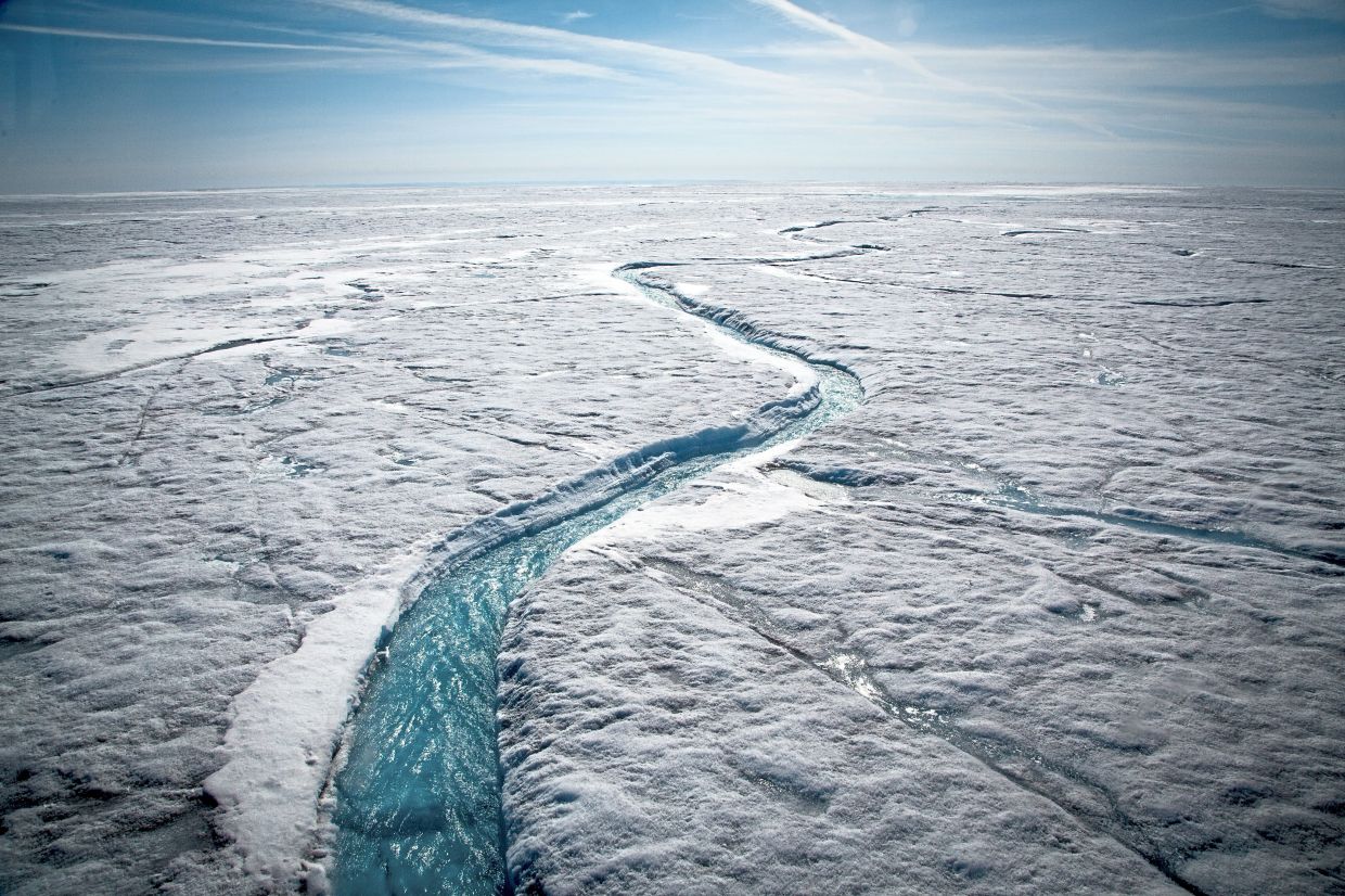 Glacial meltwater forms a river flowing atop the Greenland Ice Sheet in July 2015. — JOSH HANER/The New York Times