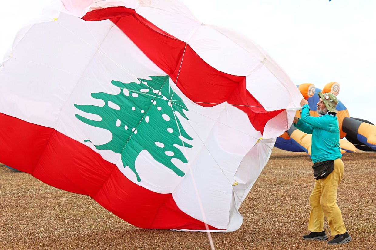 Sayegh flying a kite bearing the flag of his country Lebanon.
