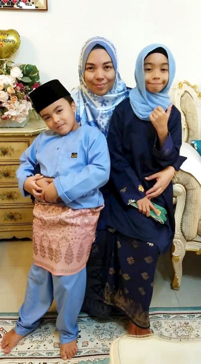 Rozaihan Abdul Rahim (centre) said her children, Muhammad Arefi (left) and Afiyya Medinah, both started fasting when they were six-years-old.