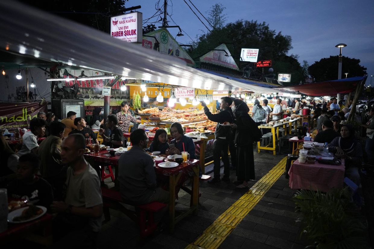 People get their iftar meals from roadside food stalls to break their fast during the second day of the holy fasting month of Ramadan in Jakarta, Indonesia, Friday, Feb. 20, 2026. -- AP Photo/Dita Alangkara