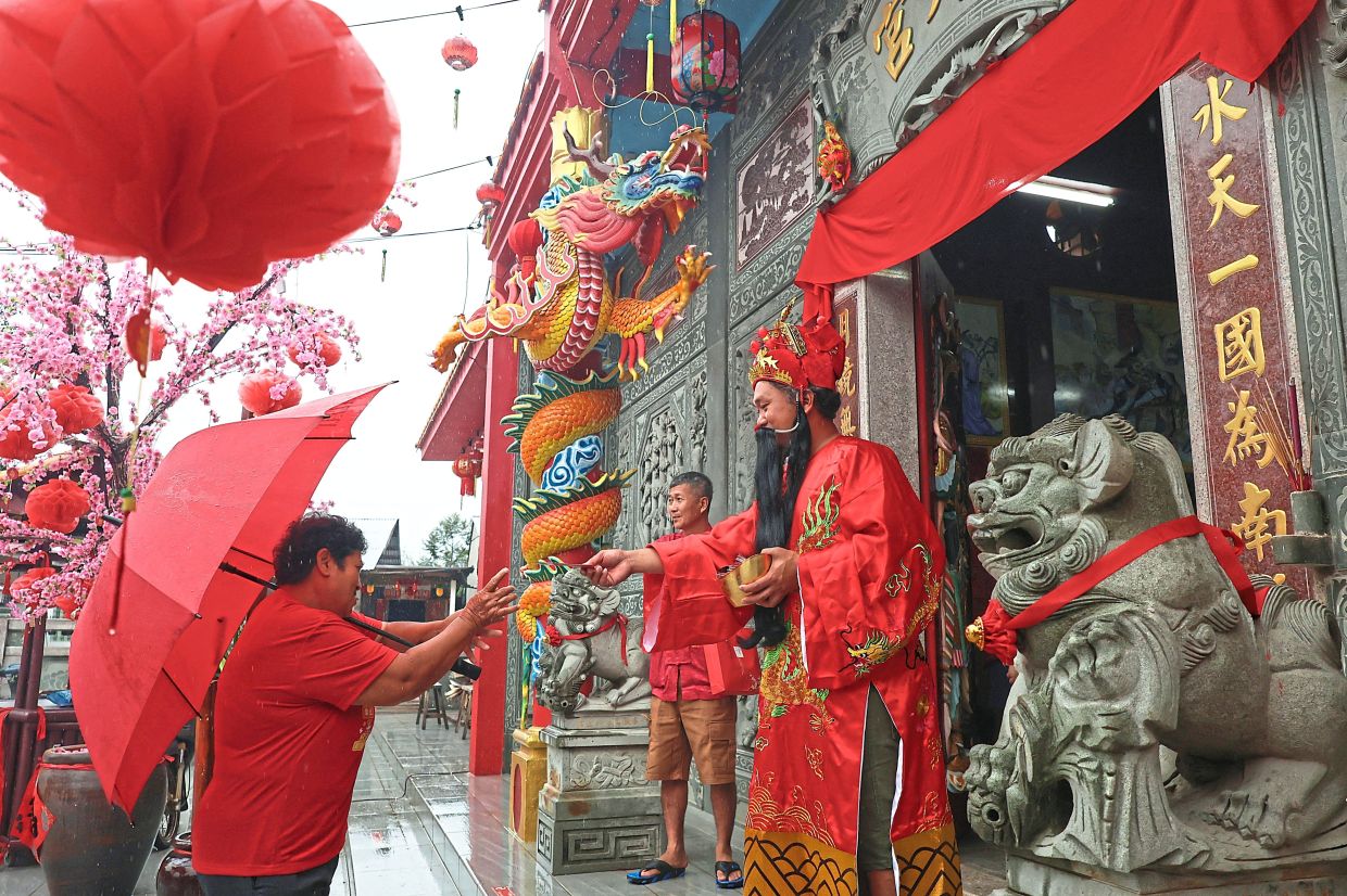 Cheaw Yee How, 42, as the God of Prosperity, welcomes visitors to Swee Nyet Keung Temple in Gua Musang, Kelantan. — Photos: Bernama