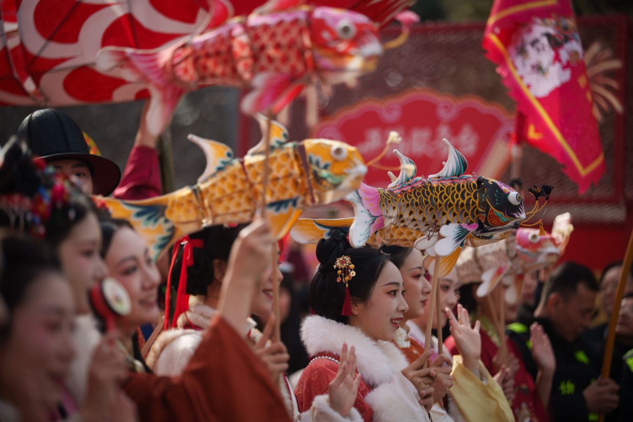 Performers carry colorful fish lanterns in a festive procession during Lunar New Year celebrations in Beijing, Saturday, Feb. 21, 2026. -- AP Photo/Vincent Thian