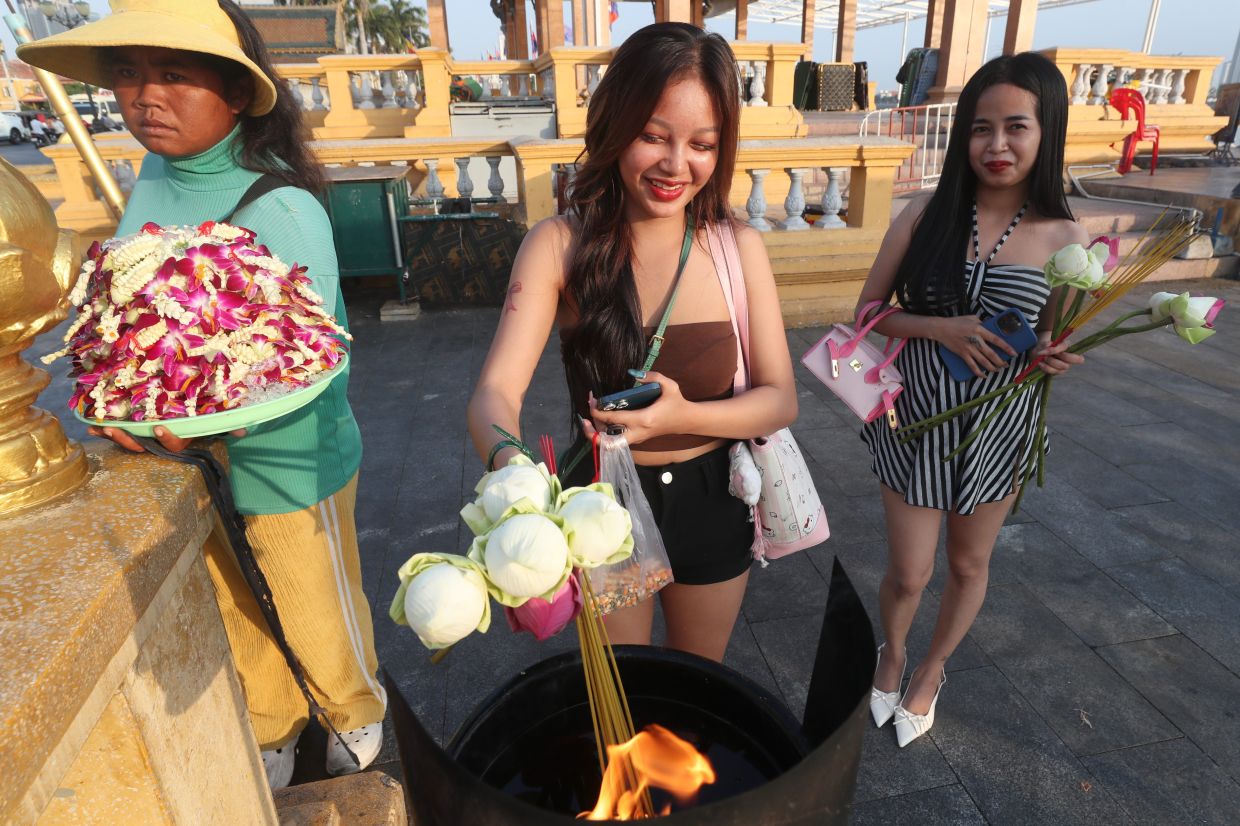 A Cambodian girl (centre) burns incense sticks for Lunar New Year celebrations in Phnom Penh. -- AP Photo/Heng Sinith