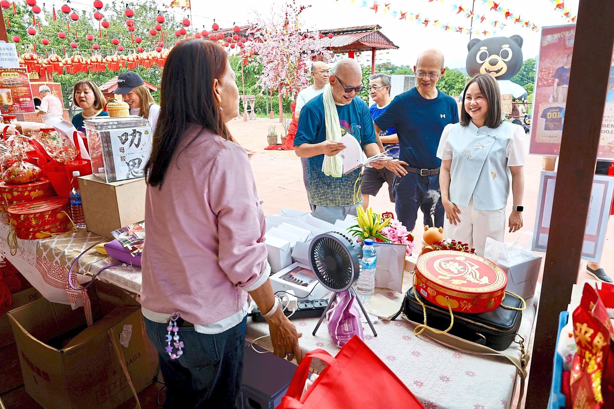 Pang (right) talking to a vendor at the bazaar.