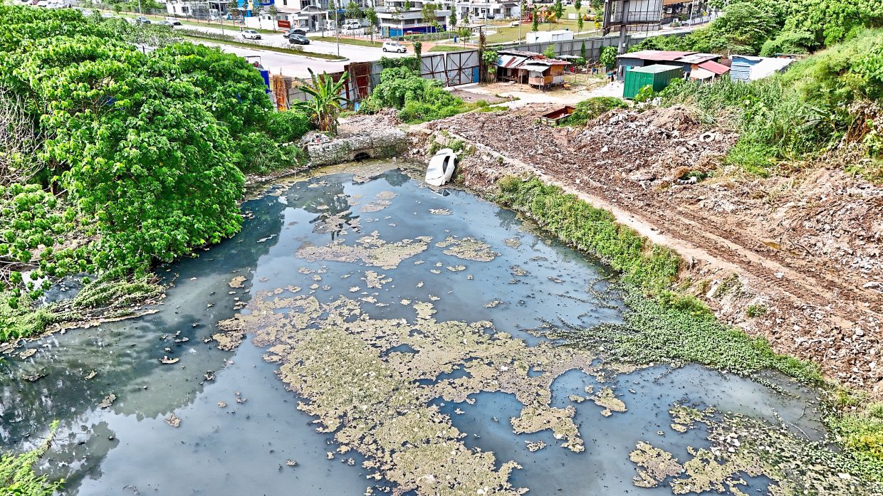 A vehicle lies partially submerged in the Sri Manja retention pond.