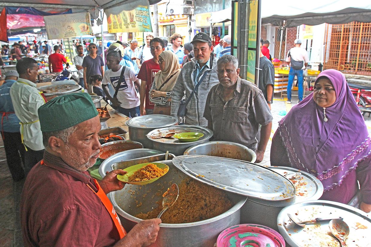 Customers making their pick of nasi biryani dishes at a stall in Lebuh Queen. 