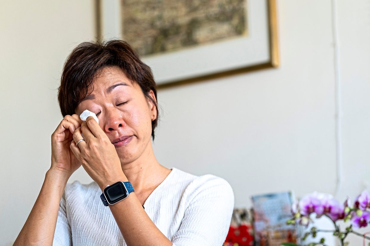 Lo wiping her tears during an interview at her house in Hong Kong. — AP