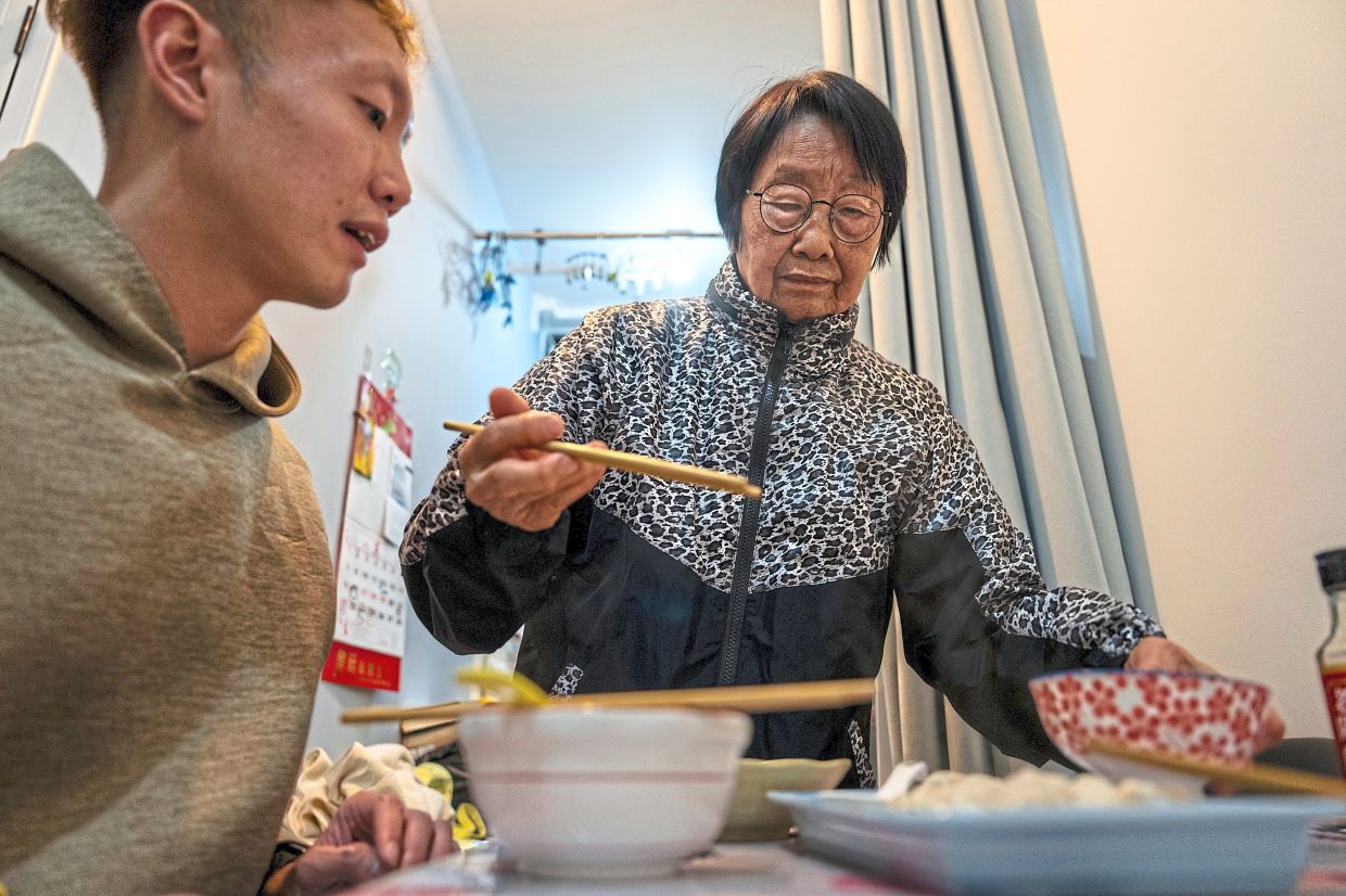Cheung (left) and Chow dining at the transitional housing provided by the government in Hong Kong. — AP