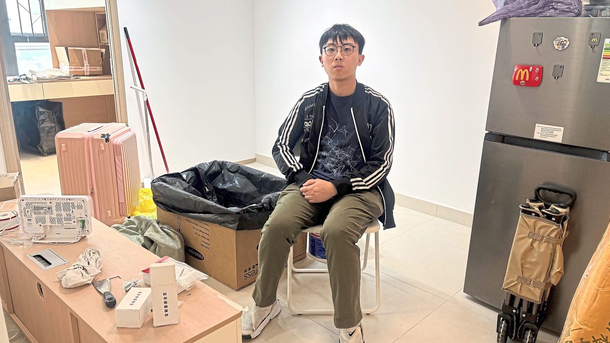 Isaac Tam poses for a photograph at his newly renovated temporary housing unit. — AP