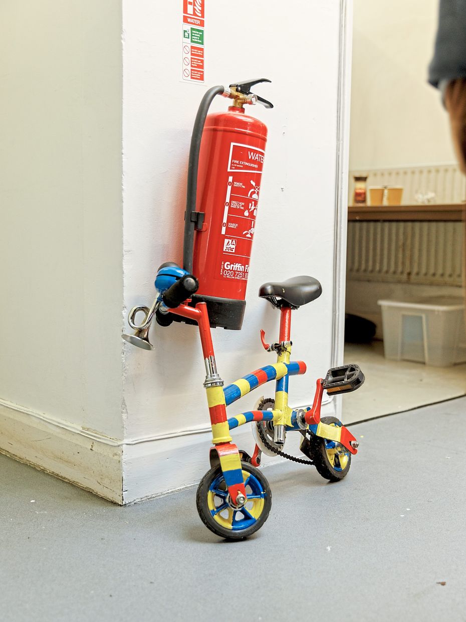 A clown bike against a wall inside the church.