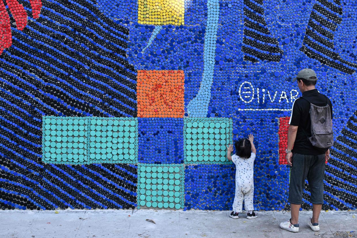 The artwork, made with more than 100,000 recycled plastic bottle caps, is regarded as the world's tallest bottle-cap mural. Photo: AFP 