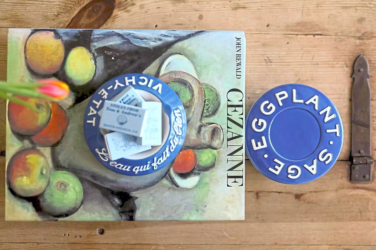 A vintage ashtray van Hulsen found on Etsy rests on top of a Cezanne book scored at a Palm Springs estate sale.