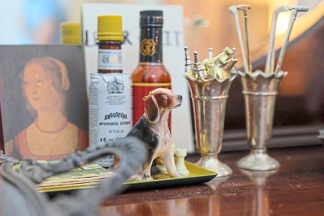 A ceramic beagle rests next to two silver toothpick holders.