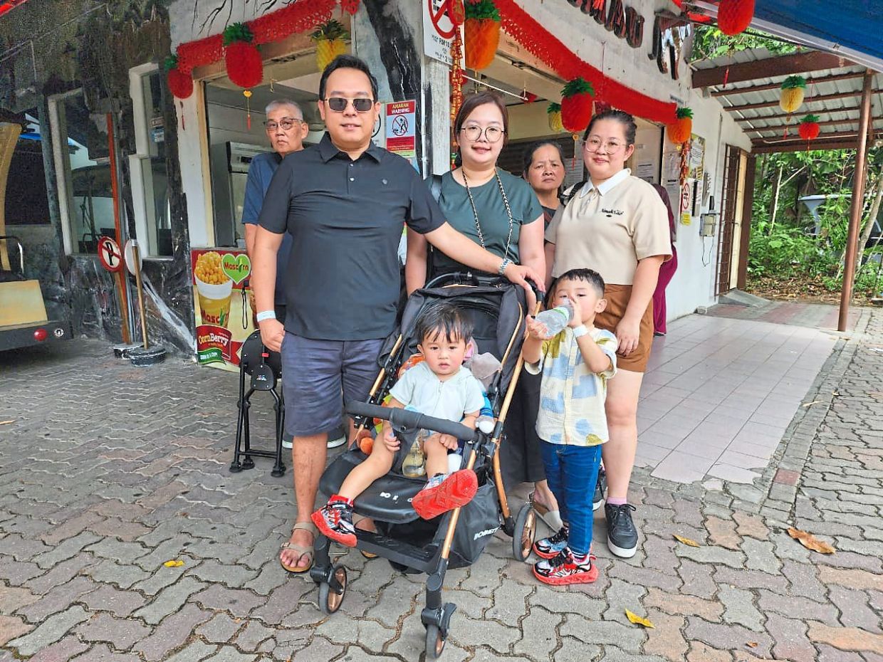 Wong (front, left) from Kuching, Sarawak, with his family at Zoo Negara after watching the lion dance performance. 