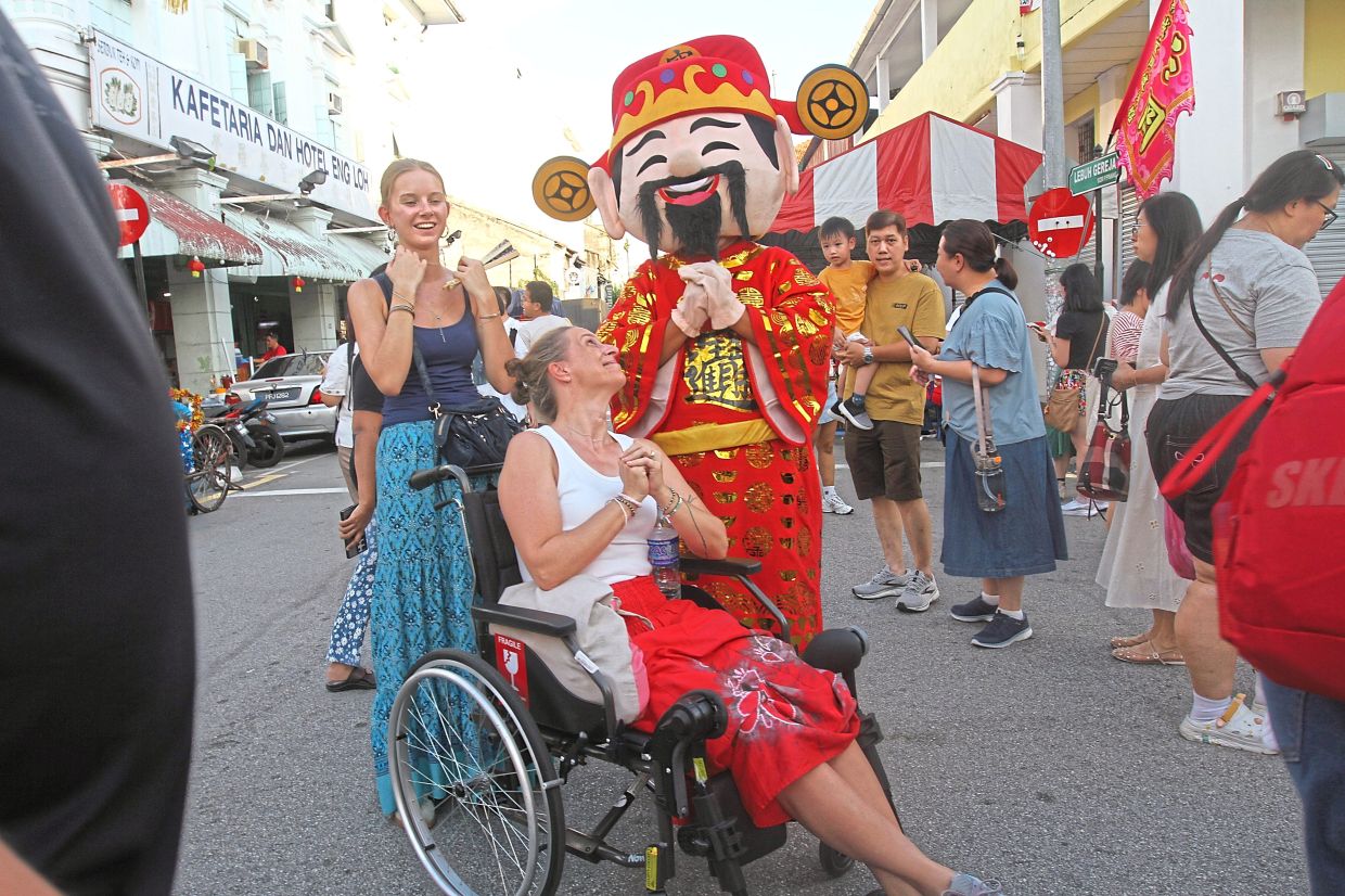 The God of Prosperity spreading Chinese New Year cheer to foreign tourists.