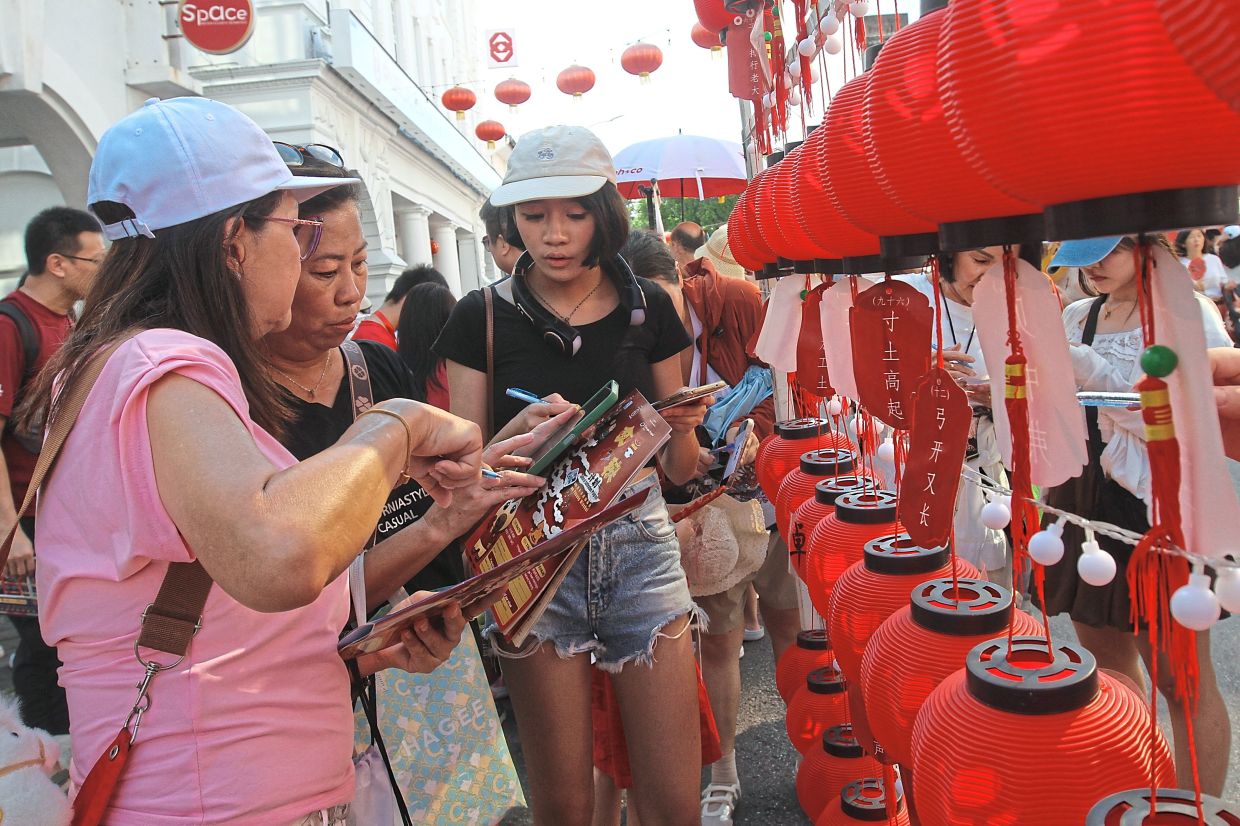 Lee (centre), her daughter Belinda (right) and a friend trying to solve lantern riddles.