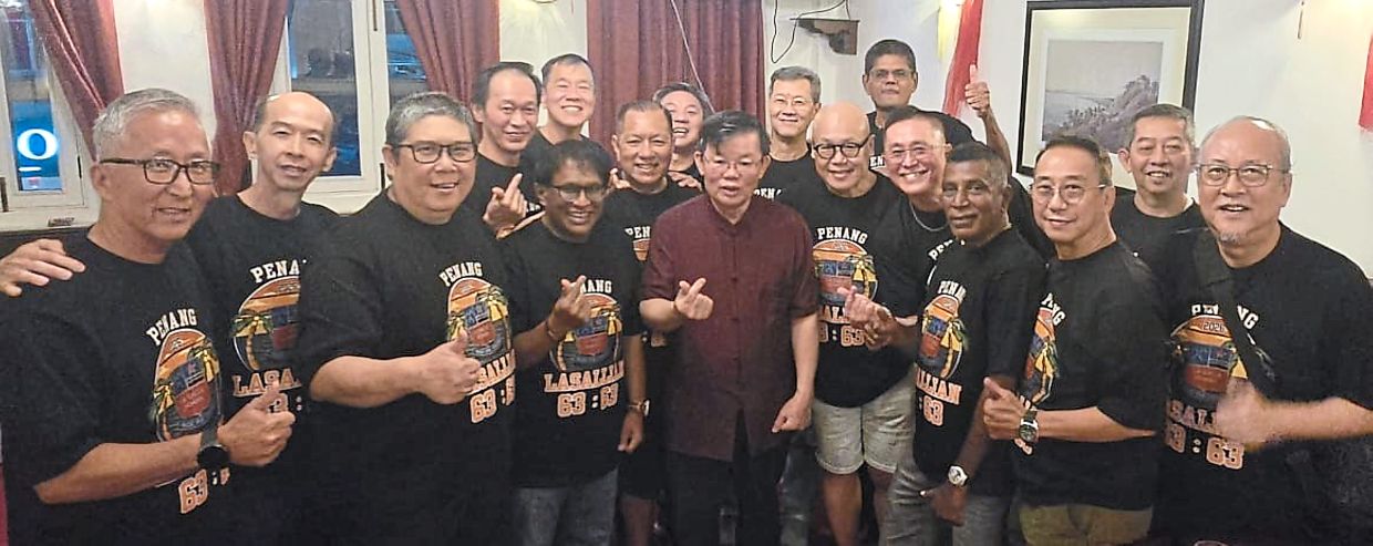 Penang Chief Minister Chow Kon Yeow (middle) poses for a photo with the men at their reunion event. - Courtesy photo
