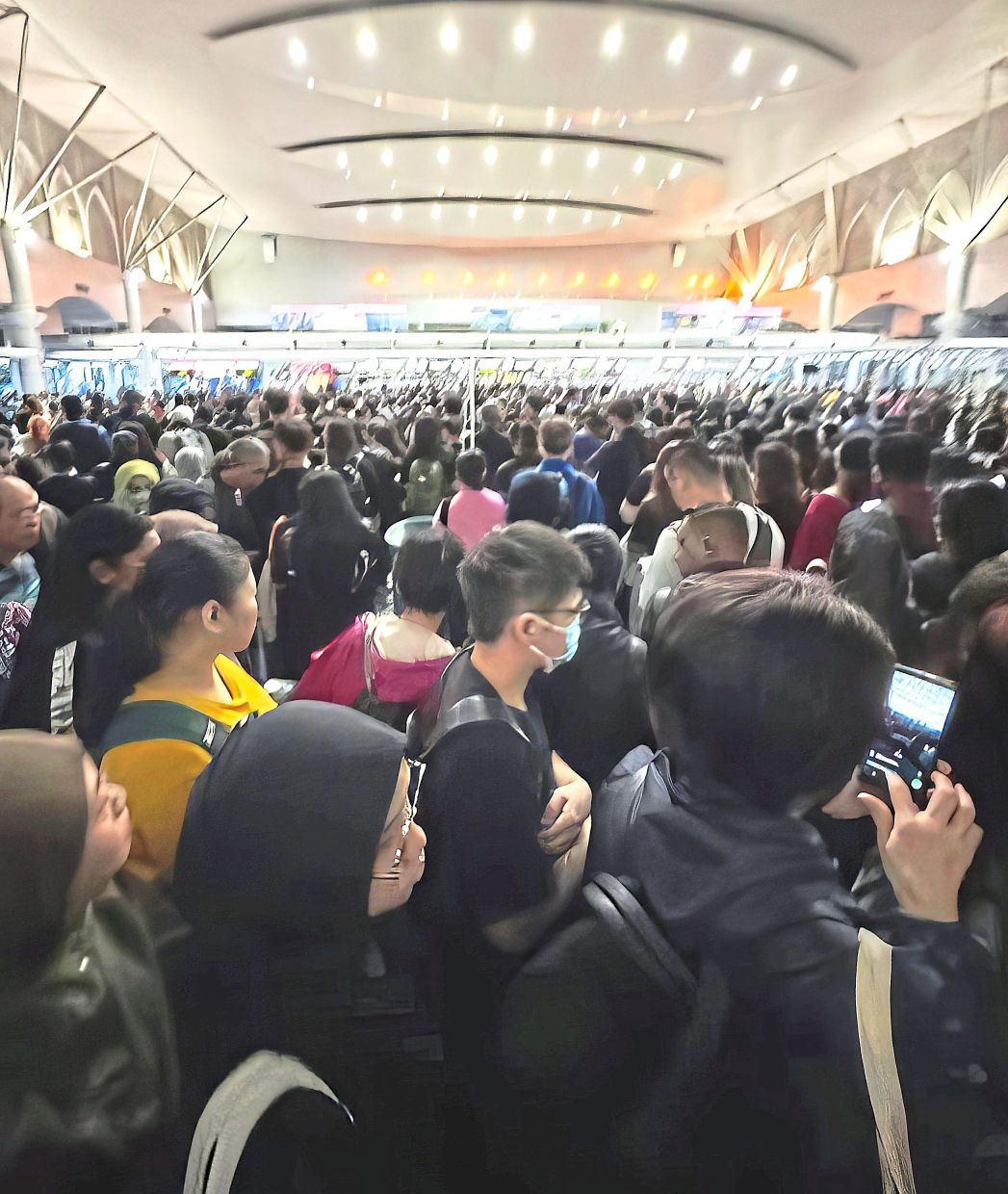 Stuck in place: Passengers waiting to clear immigration manually following the latest network outage at the BSI in Johor Baru.