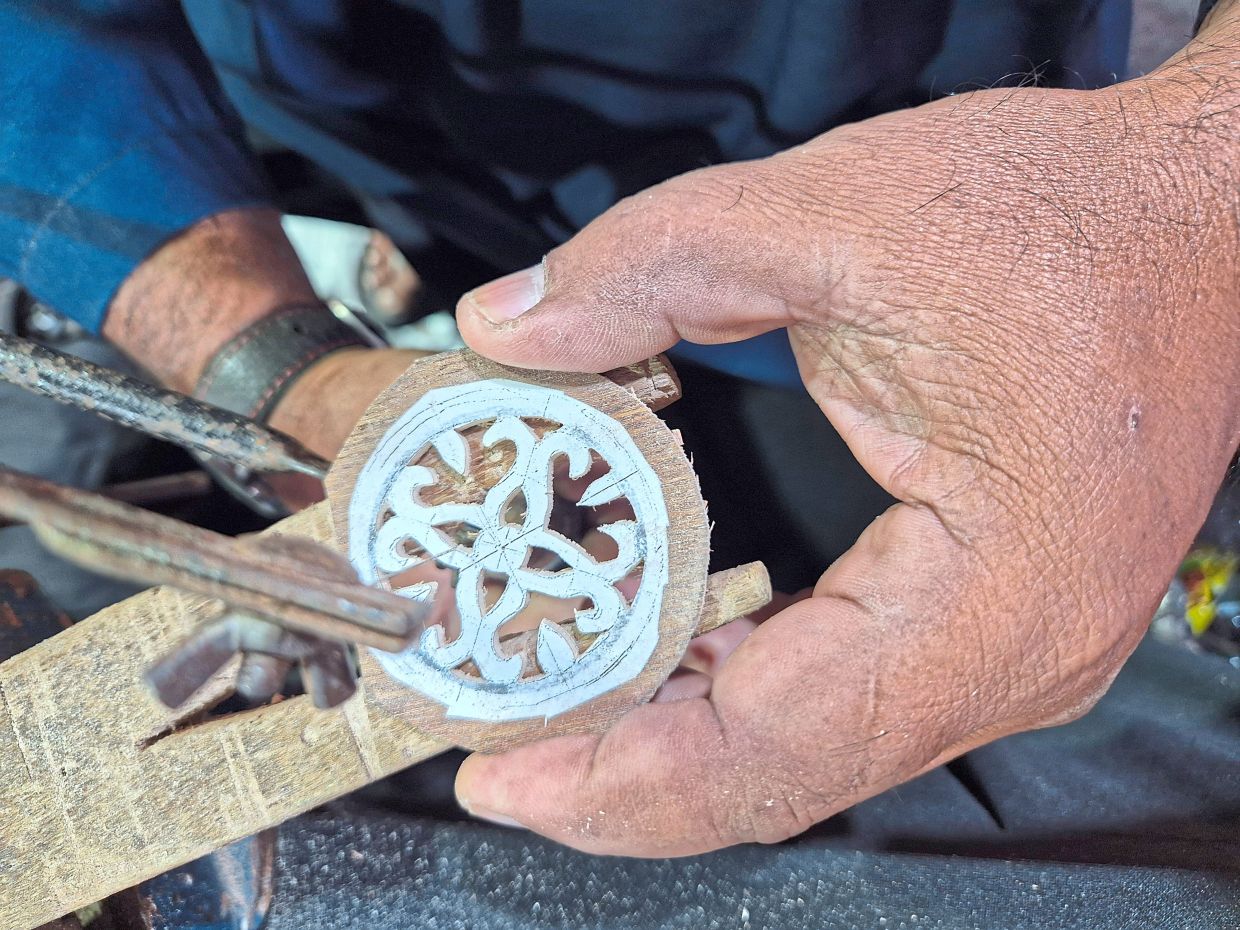 The gambus features detailed Malay carvings inspired by local heritage.