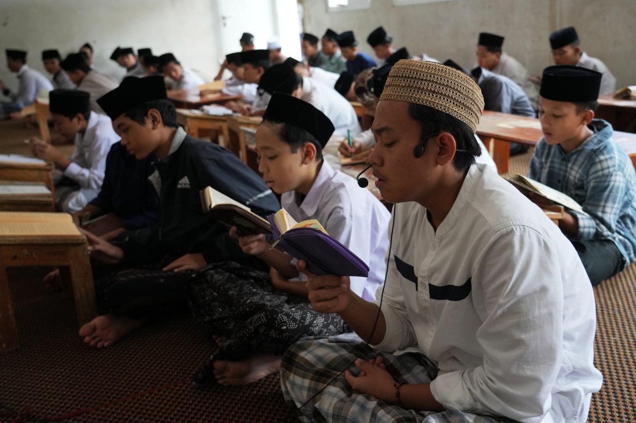 Students sit as they read the Quran during the holy fasting month of Ramadan at Sirajussa' Adah Islamic Boarding School in Depok, on the outskirts of Jakarta, Indonesia, Friday, Feb. 27, 2026. -- AP Photo/Tatan Syuflana