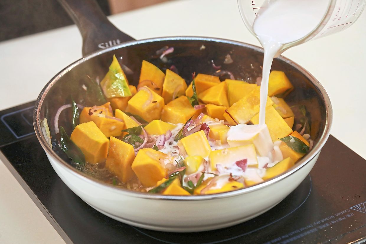 Pour fresh coconut milk to the sauteed ingredients.