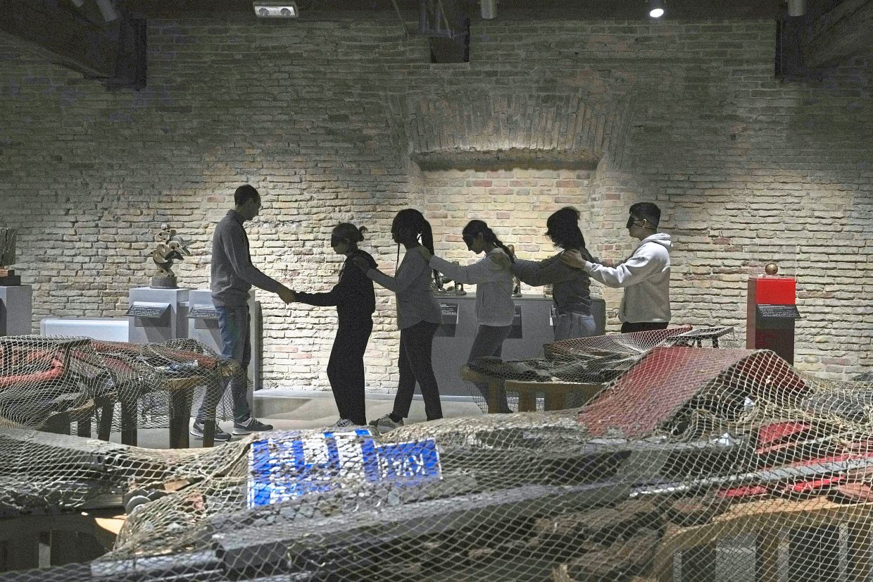 Blindfolded students of an art high school enter the pavilion of contemporary art for a project on tactile experience at the Omero Tactile Museum. Photo: AP