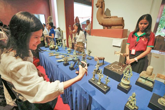 A woman takes pictures of sculptures. - Photo: AFP