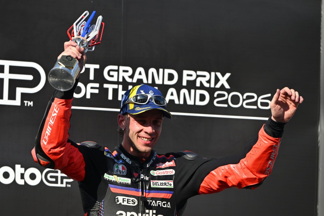 MotoGP winner Italy's rider Marco Bezzecchi celebrates on the podium after the MotoGP at the Chang International Circuit in Buriram, Thailand, on Sunday, March 1, 2026. -- AP Photo/Kittinun Rodsupan