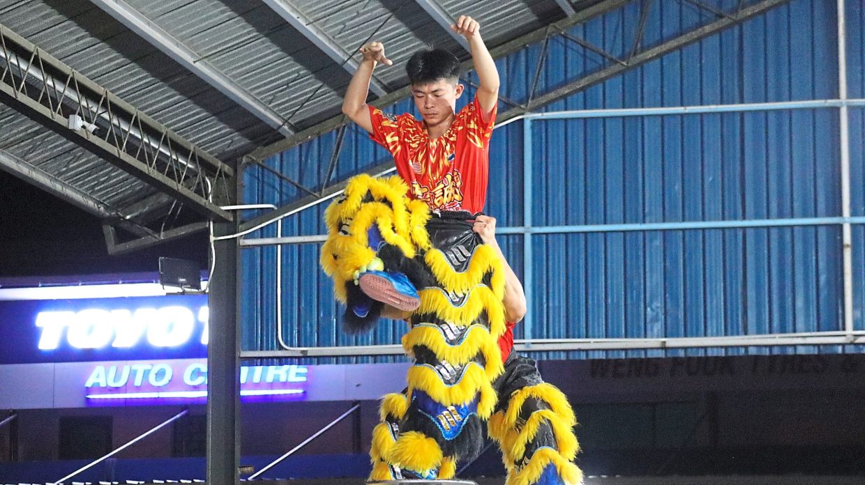 A Chung Seng performer balances mid-air during an intense high-pole lion dance training session in Sandakan.