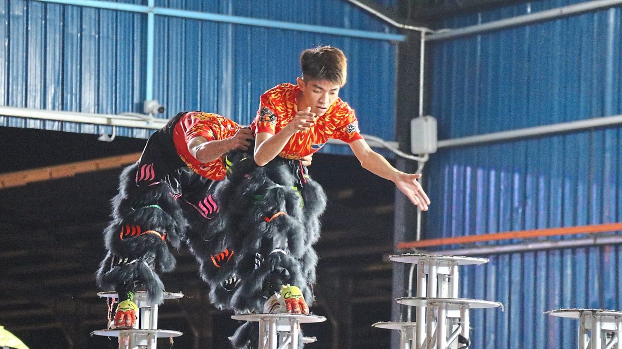 Precision and trust as teammates guide a daring leap between poles during night practice.