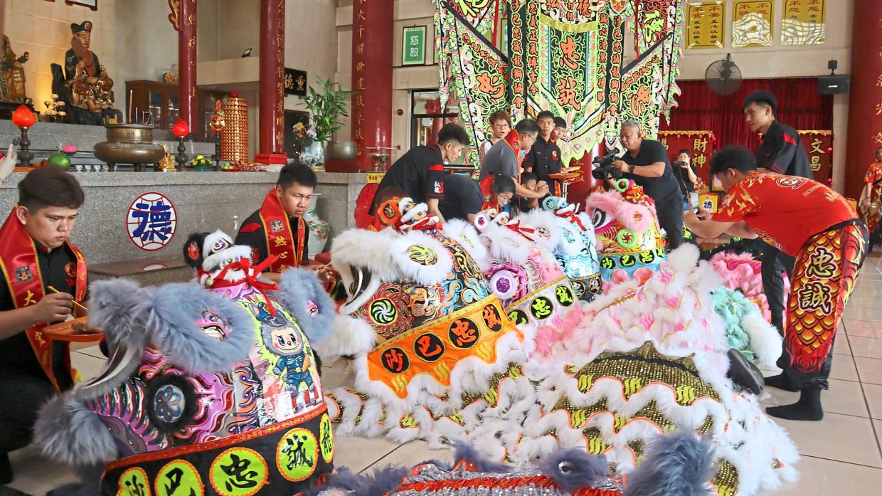 Chung Seng members carrying out the symbolic eye-dotting ceremony to awaken new lion heads before the festive season in Sandakan.