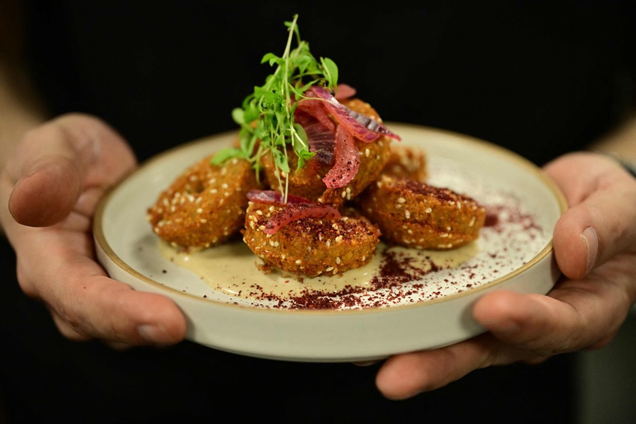 Imad Alarnab with a plate of food at one of his restaurants in central London.