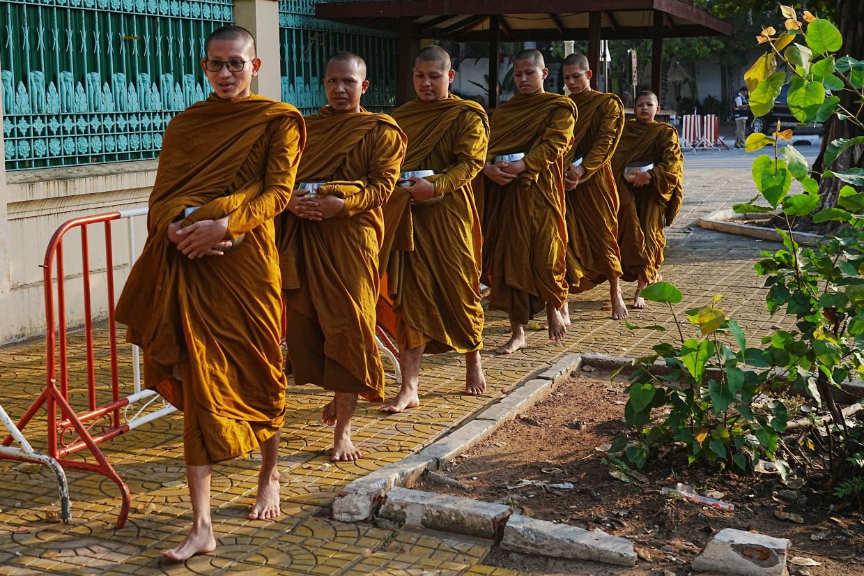 Cambodian Buddhist monks walk after they receive arms from inside the Royal Palace in Phnom Penh, Cambodia, on Monday, March 2, 2026. -- AP Photo/Heng Sinith