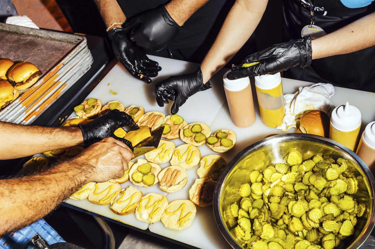 The kitchen crew from NFA Burger prepares their burgers at the Burger Bash.