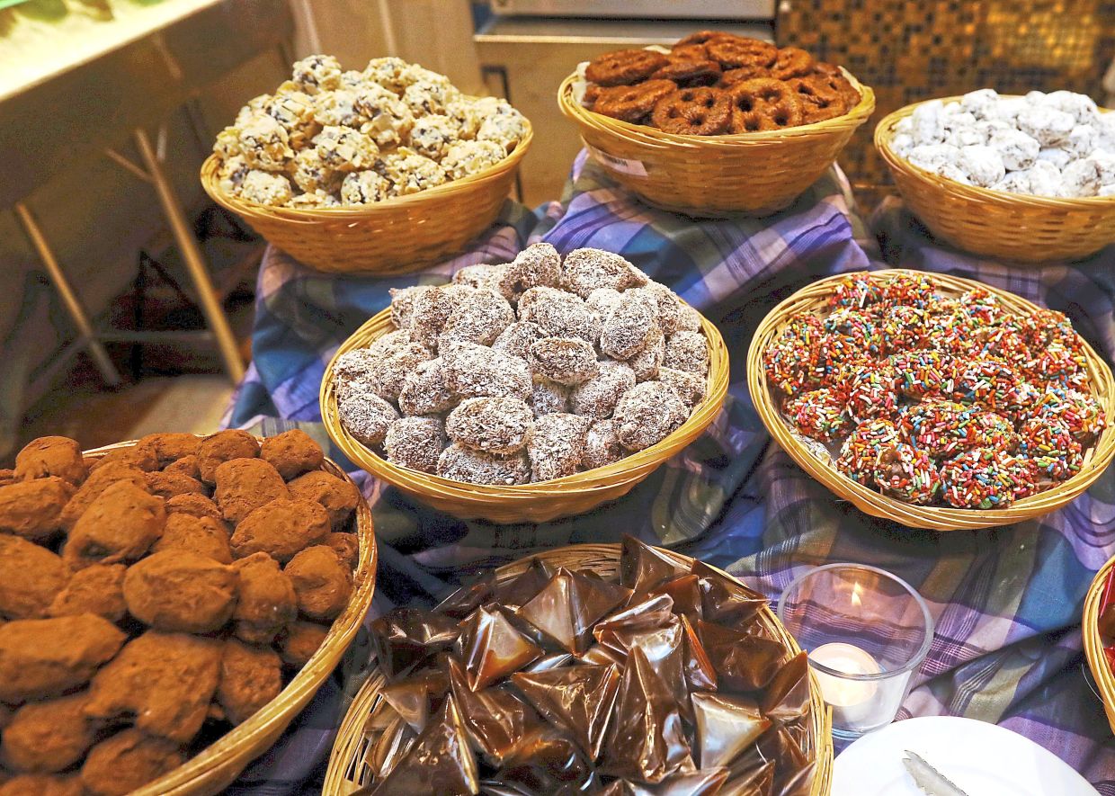 The ‘Jelajah Selera Ramadan’ buffet at Crystal Crown Hotel Petaling Jaya offers a variety of break of fast treats including an assortment of stuffed dates (above), and anchored by its signature Salmon Fish Head Claypot Curry (right).(Far right) Live stations and local favourites such as Prawn in Soy Sauce round up the dining experience. — Photos: AZLINA ABDULLAH/The Star