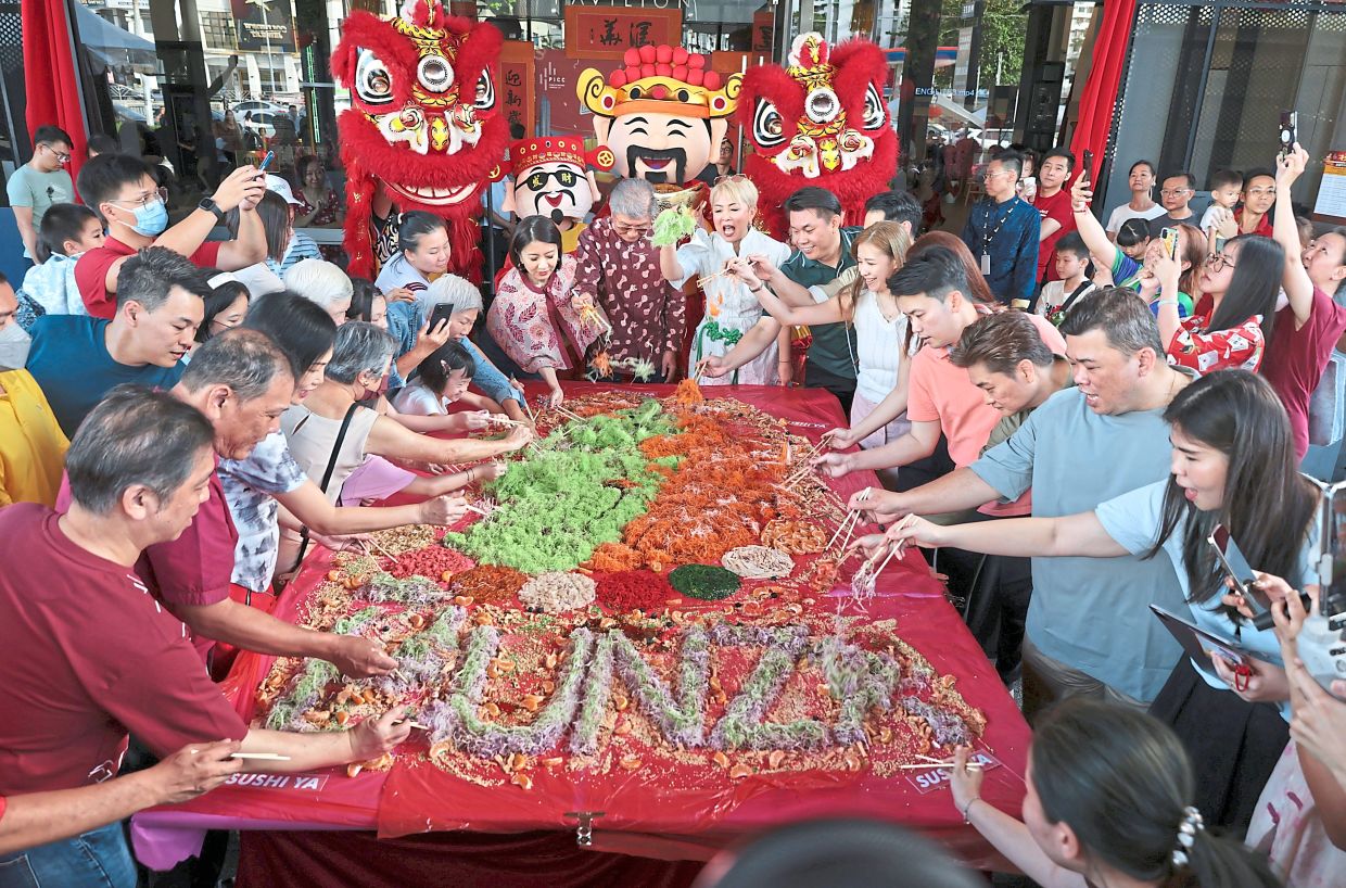 Khor (centre) with Lily (centre, right) and Tze Ming (centre, left) at the yee sang tossing ceremony.