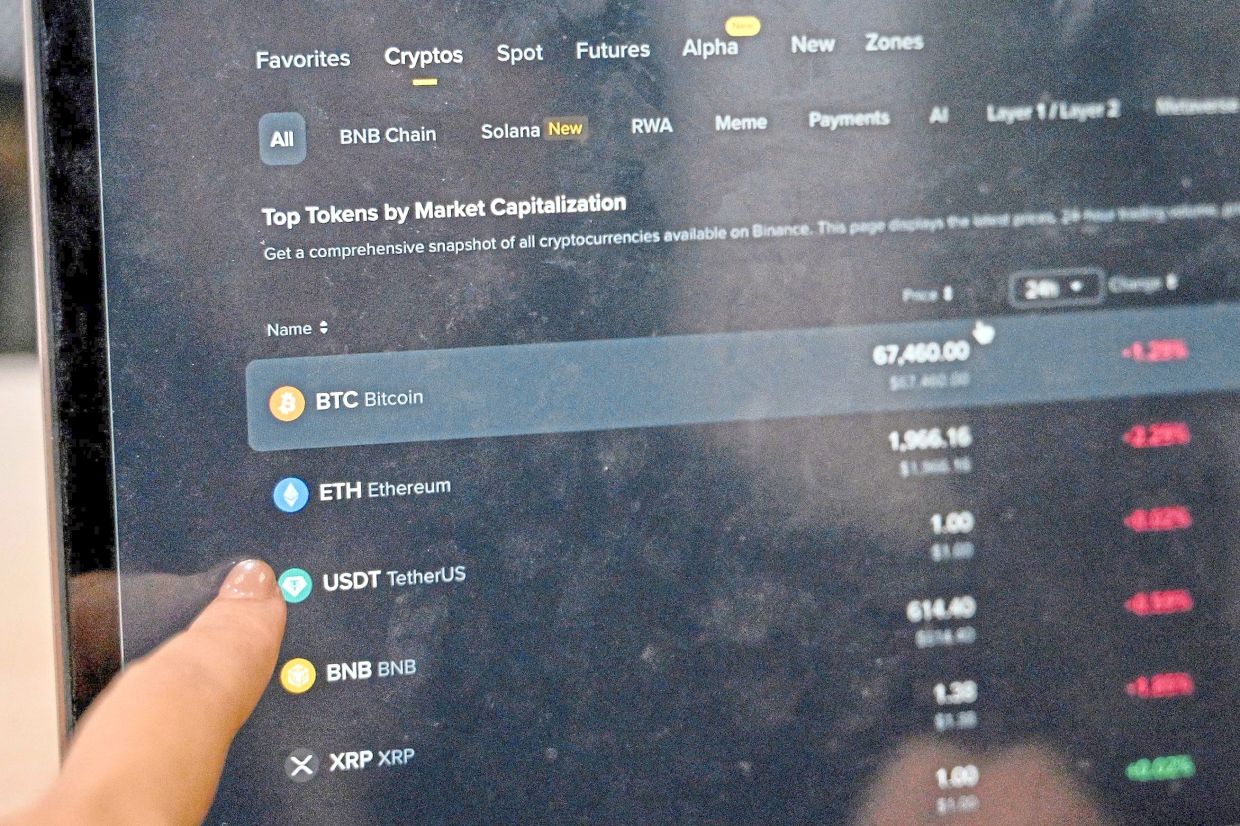 Downward trend: Cryptocurrency investors looking at the latest cryptocurrencies’ values on a laptop in Hanoi. Unlike neighbouring China which has banned cryptocurrencies outright, Vietnam has allowed blockchain technology to develop in a legal grey area. — AFP 
