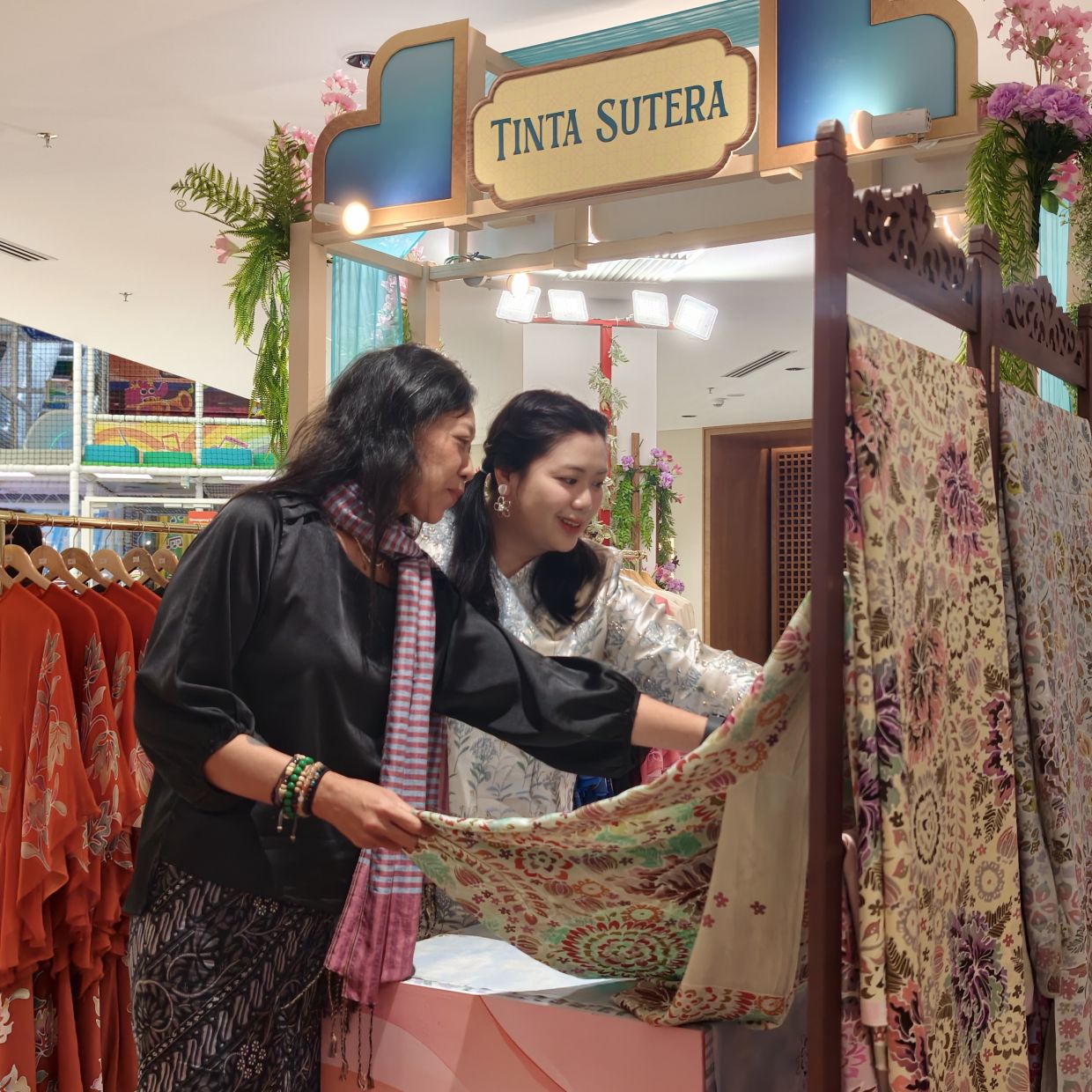 Shoppers exploring festive textiles at the KLGCC Raya bazaar.