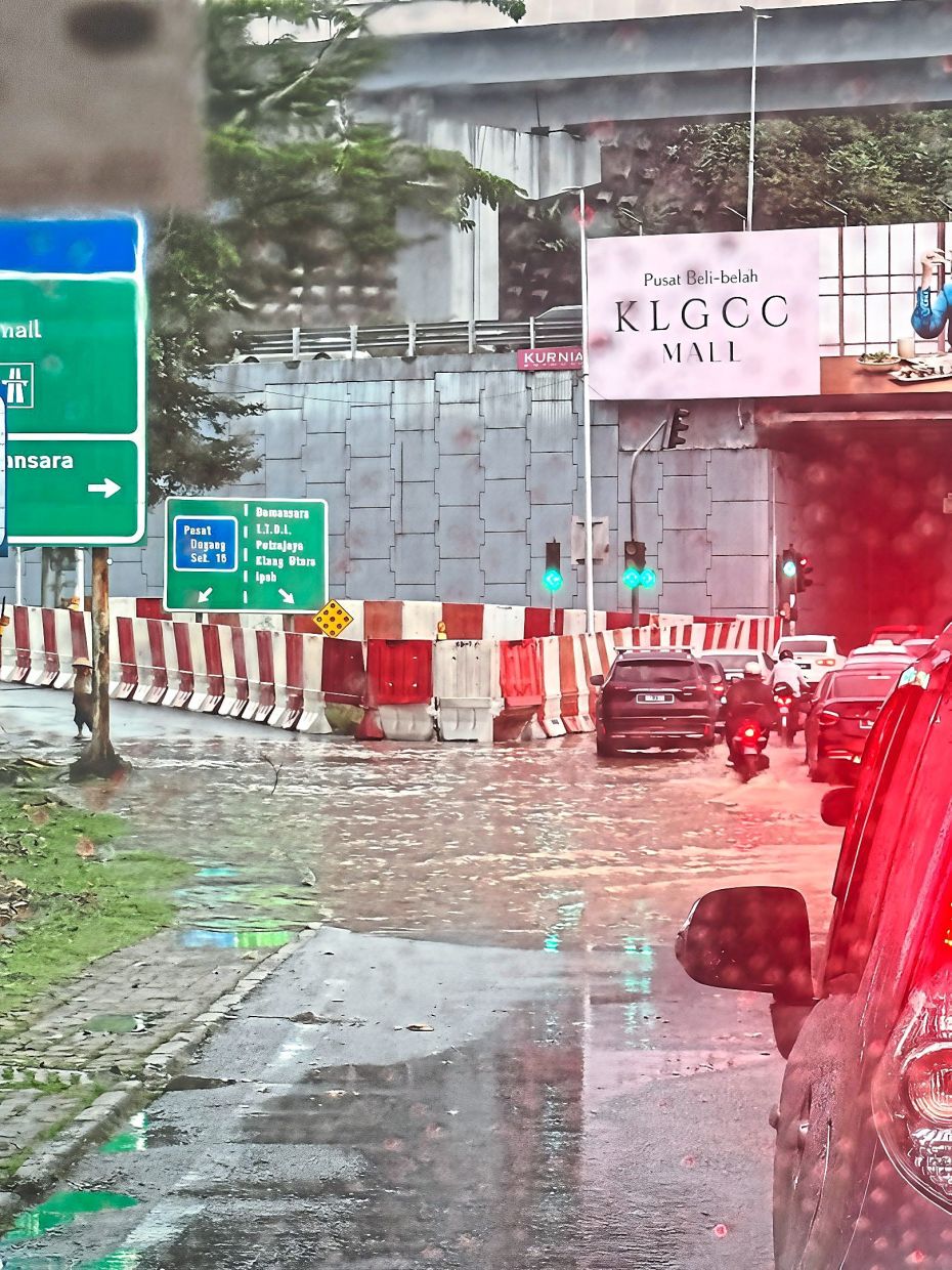 Flooding at Jalan 16/1 intersection leading to Sprint Highway, next to an area with ongoing construction.