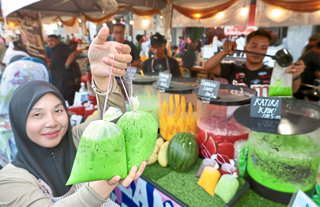 Fazira showing two packets of katira — a fragrant mix of pandan, basil seeds and grass jelly — at her stall at the Prangin Mall Ramadan bazaar in George Town. 