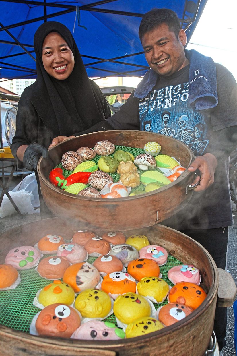 Muhammad Faizul (right) and Nuramalina with their ‘Pau Comey’ at a bazaar along Jalan Mahkamah in Bayan Lepas. 