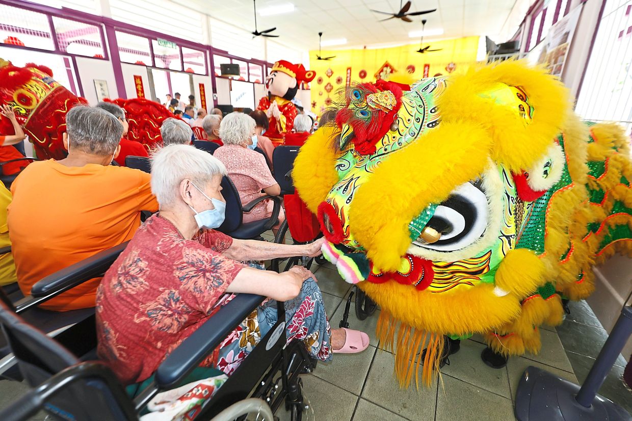 A resident patting the head of a lion during the lion dance performance.
