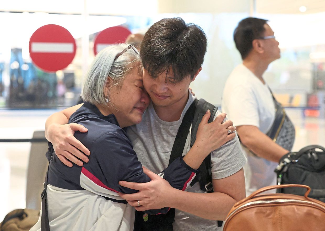 Tears of relief: Cynthia Chew getting a hug. — Reuters 