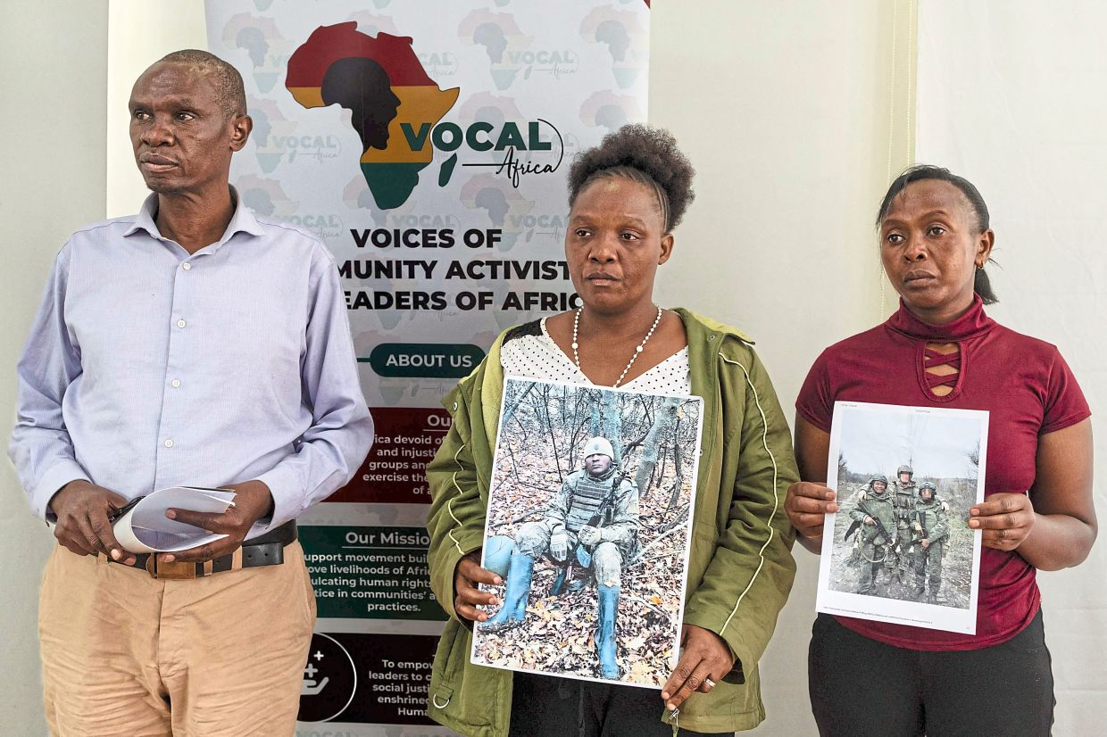 Relatives of Kenyan nationals conscripted by the Russian army in Ukraine posing with photos of their family members during a press conference demanding urgent government action to repatriate their kin.