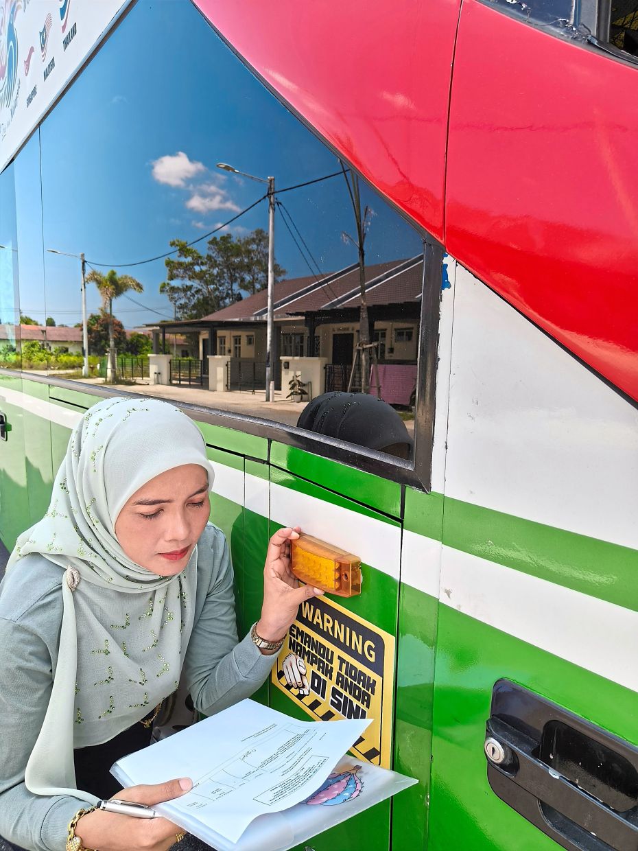 Safety comes first: Siti Azmira inspects the bus before a journey.